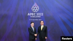 香港特首李家超（左）2022年11月18日在出席亚太经合组织峰会期间与东道主泰国总理握手。（亚太经合组织2022年峰会照片）