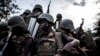Des militaires des Forces armées de la RDC, FARDC, avec leurs armes dans un véhicule et sur la route combattant le M23 à Oicha, territoire de Beni, Nord-Kivu, 7 octobre 2018.