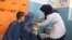 عکس: په بغلان کې یوه ښځینه واکسیناتوره یو ماشوم ته د پولیو واکسین تطبیقوي