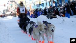 Defending champion Brent Sass mushes his dog team down Fourth Avenue during the Iditarod Trail Sled Dog Race's ceremonial start in downtown Anchorage, Alaska, on Saturday, March 4, 2023. (AP Photo/Mark Thiessen)