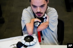 Martin Shane uses a Sony Access controller, left, to play a video game at Sony Interactive Entertainment headquarters Thursday, Sept. 28, 2023, in San Mateo, Calif. (AP Photo/Godofredo A. Vásquez)