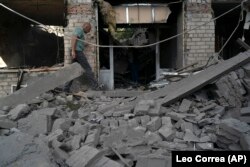 FILE - A man walks over debris of a psychiatric hospital that was heavily damaged after a Russian attack in Kramatorsk, Ukraine, Sept. 7, 2022. (AP Photo/Leo Correa, File)