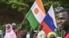 Des drapeaux nigérien et russe tenus par des citoyens au stade Général Seyni Kountche à Niamey, le 26 août 2023. AFP
