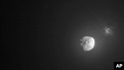 FILE - Debris ejects from the asteroid Dimorphos, right, a few minutes after the intentional collision of NASA’s Double Asteroid Redirection Test mission on Sept. 26, 2022, captured by the nearby Italian Space Agency’s LICIACube. (NASA)