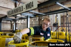 An operator prepares used cylinders to be drained of remaining refrigerant at the A-Gas Rhome facility on Monday, Oct. 9, 2023, in Rhome, Texas. (AP Photo/Sam Hodde)