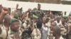 Cette capture vidéo de Gabon 24, le 30 août 2023, montre des soldats gabonais transportant le général Brice Oligui Nguema (au centre), chef de la garde présidentielle du président déchu Ali Bongo Ondimba. (Photo AFP / Gabon 24)