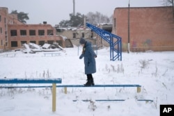 FILE - A child plays near School No. 21, which was destroyed by the Russian army, in Chernihiv, Ukraine, on Jan. 16, 2023. (AP Images for Global Partnership for Education)