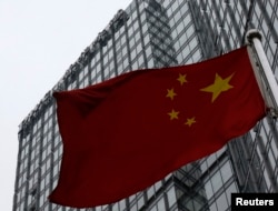 资料照：一面中国国旗在普华永道在北京的办公楼前飘扬。（2024年1月24日）