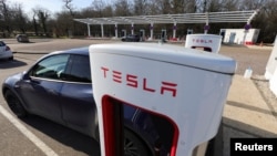 A driver recharges the battery of his Tesla car at a Tesla Super Charging station on the highway in Chateauvillain, France, February 20, 2023. (REUTERS/Pascal Rossignol)