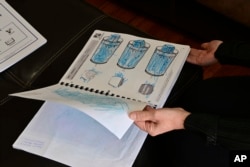 Parent Isabel Valencia holds the first-year program portfolio of her daughter, Celeste on Wednesday, Feb. 28, 2024. (AP Photo/Eric Lars Bakke)