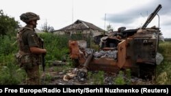 Украинский военнослужащий стоит рядом с уничтоженной российской БМП-3 в недавно освобожденном селе Благодатное в Донецкой области, Украина, 17 июня 2023 года