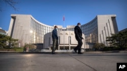 资料照片：戴着口罩的行人从北京的中国人民银行前走过。（2023年3月3日）