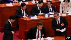 中国领导人习近平、总理李强和全国政协主席王沪宁在人大会堂进行的全国人大会议上。（2024年3月5日）