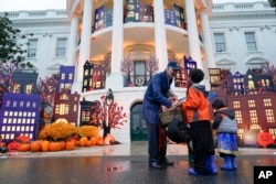 FILE - President Joe Biden and first lady Jill Biden give treats to trick-or-treaters on the South Lawn of the White House, on Halloween, Oct. 31, 2022, in Washington. (AP Photo/Alex Brandon)