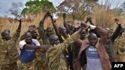 Des soldats stagiaires pour une nouvelle armée unifiée lèvent les mains jointes alors qu'ils assistent à un programme de réconciliation organisé par la (MINUSS) dans une caserne de fortune à Mapel le 31 janvier 2020. (Photo by TONY KARUMBA / AFP)