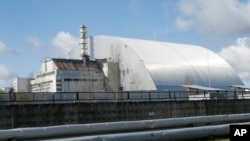 In this file photo, a shelter construction covers the exploded reactor at the Chernobyl nuclear plant, in Chernobyl, Ukraine, on April 27, 2021. (AP Photo/Efrem Lukatsky, File)