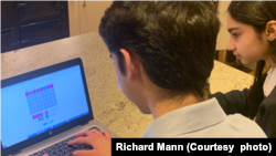 Children play Nerdle on a laptop computer.