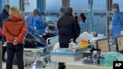 Medical workers check on an elderly patient arrives to an emergency hall in a hospital in Beijing, Saturday, Jan. 7, 2023. (AP Photo/Andy Wong)