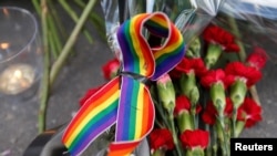 Un ruban arc-en-ciel, une bougie et des fleurs pour les victimes de la fusillade dans une boîte de nuit gay à Orlando sont visibles devant l'ambassade des États-Unis à Moscou, en Russie, le 13 juin 2016. (Maxim Zmeyev /Reuters)