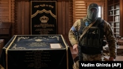 Член охоронної команди всередині синагоги в єврейському поселенні Анатевка поблизу Києва. Фото зроблене 27 березня 2022 року, AP Photo/Вадим Гірда