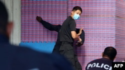 资料照：所罗门皇家警察部队2022年3月29日发布没有注明时间的照片显示，中国警察联络官（中）在训练所罗门警察格斗技术。