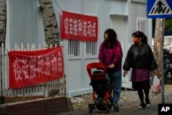 北京居民走过一个新冠病毒疫苗流动接种点。（2022年10月26日）