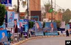 Campaign posters for Iraqi Sunni political blocks line a street in the predominately Sunni neighborhood of Azamiya, in north Baghdad, Iraq, May 8, 2018.