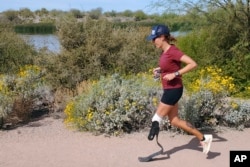 In this image provided by Edwin Broersma, marathoner Jacky Hunt-Broersma runs her 80th consecutive marathon on March 27, 2022, near her home in Gilbert, Az. (Edwin Broersma via AP)