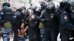 La police détient un homme et une jeune femme lors d'une manifestation contre l'emprisonnement de l'opposant Alexei Navalny à Moscou, Russie, le 23 janvier 2021. 