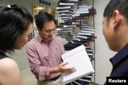 Scientist He Jiankui shows "The Human Genome," a book he edited, at his company Direct Genomics in Shenzhen, Guangdong province, China August 4, 2016.