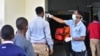 Un travailleur vérifie la température des voyageurs au poste frontière avec le Kenya à Namanga, dans le nord de la Tanzanie, le 16 mars 2020.