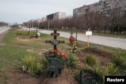 Graves of civilians killed during Ukraine-Russia war are seen next to apartment buildings in the southern port city of Mariupol, Ukraine, April 10, 2022. (REUTERS/Alexander Ermochenko)