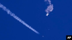 FILE - In this photo provided by Chad Fish, the remnants of a large balloon drift above the Atlantic Ocean, just off the coast of South Carolina, after being shot down by U.S. jet fighter on Feb. 4, 2023. (Chad Fish via AP, File)