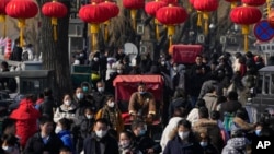 北京后海一条熙熙攘攘的街道，传统的三轮儿在人群中穿行。(2023年1月30日)