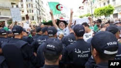 Des manifestants algériens font face à la police anti-émeute lors d'une manifestation dans la capitale Alger, le 21 juin 2019. 