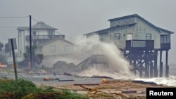 Waves crash on stilt houses along the shore as Hurricane Michael's power is unleashed in Alligator Point, Franklin County, Fla., Oct. 10, 2018.