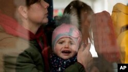 A Ukrainian child reacts as he boards a bus after arriving at Hendaye train station, southwestern France, Wednesday, March 9, 2022. (AP Photo/Bob Edme)