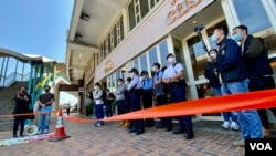 香港警方在距离北京驻港机构中联办超过100米的一间餐厅门外，拉起封锁线设立“示威区”，禁止两名社民连成员靠近中联办示威 (美国之音/汤惠芸)