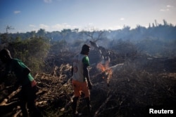 Felix Fitiavantsoa, 20, and his brother start a fire in a wooded area in order to start cultivating it, in the Tsihombe commune, Androy region, Madagascar, February 13, 2022. (REUTERS/Alkis Konstantinidis )