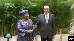 2022年12月8号，中国总理李克强和世界贸易组织总干事恩戈齐·奥孔乔-伊维拉在中国安徽黄山举行会谈前握手拍照。随着中调整其新冠对抗政策，中国有信心使经济恢复持续发展。照片发自中国中央电视台，由美联社提供。