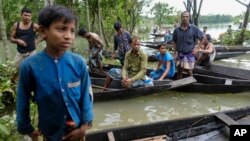 Flood affected people wait to receive relief material in Sylhet, Bangladesh, Wednesday, June 22, 2022. (AP Photo/Mahmud Hossain Opu)