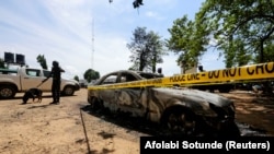 Un agent de sécurité avec un chien renifleur surveille la prison de Kuje, près d'Abuja, au Nigeria, le 6 juillet 2022. 