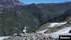 Eric Marechal, researcher at the Cell and Plant Physiology Laboratory at CEA, points to an area of search to find the Sanguina nivaloides algae, also known as "snow blood." (REUTERS/Denis Balibouse)