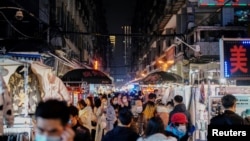 People visit a street market almost a year after the global outbreak of the coronavirus disease (COVID-19) in Wuhan, Hubei province, China December 7, 2020. (REUTERS/Aly Song)