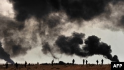 Des Libyens rebelles se préparent à aller se battre à Ras, près de l'incendie d'un oléoduc, le 9 mars 2011.