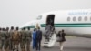 Les chefs militaires maliens saluent l'ancien président nigérian Goodluck Jonathan à son arrivée à l'aéroport de Bamako avant une rencontre entre les chefs militaires maliens et une délégation de la CEDEAO qu'il dirige le 22 août 2020.