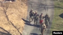 Des agents du FBI arrêtent Jack Teixeira (en rouge) à North Dighton, au Massachusetts (États-Unis), le 13 avril 2023. Photo: WCVB-TV via ABC via REUTERS.