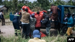 Un corps est hissé sur un camion dans le village de Manzalaho à la suite d'une attaque qui aurait été perpétrée par le groupe rebelle ADF près de Beni en RDC le 18 février 2020. (Photo: Alexis Huguet / AFP)