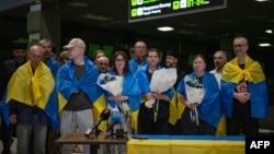 Громадяни України, які повернулися з російського полону під час обміну полоненими. У результаті угоди за посередництва Ватикану було звільнено 10 мирних жителів, у тому числі політика та двох священників. Київ 29 червня 2024 року. (Фото пресслужба Міноборони України/AFP)