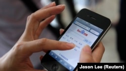 资料照：中国北京的一位手机用户用智能手机上搜索网站百度